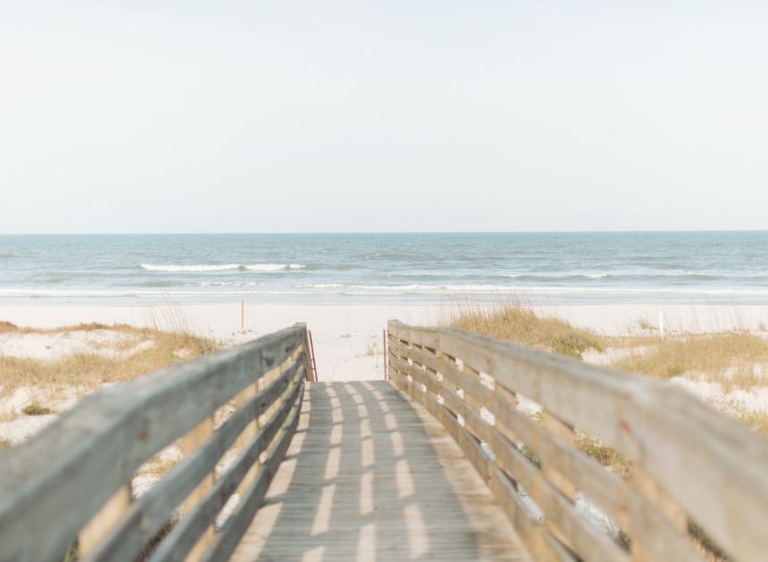 wooden path leading to a tranquil beach